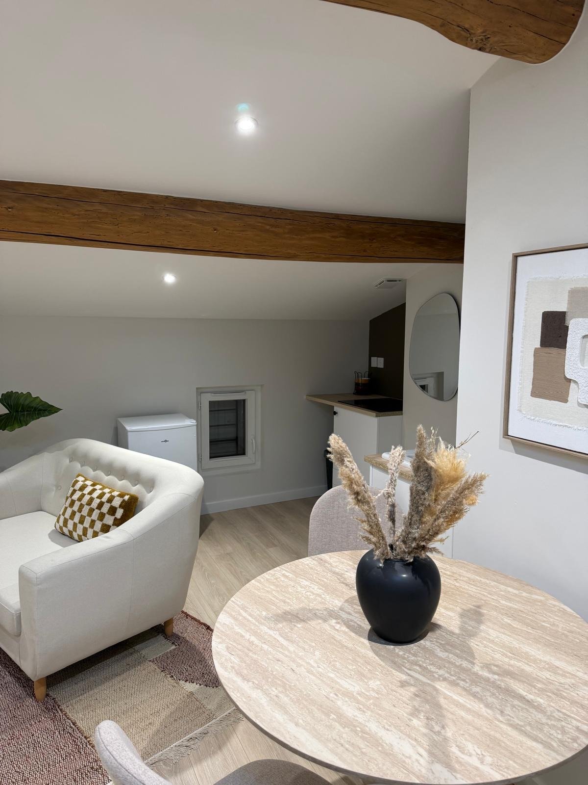 Salon cosy avec fauteuil, table en travertin et miroir arche