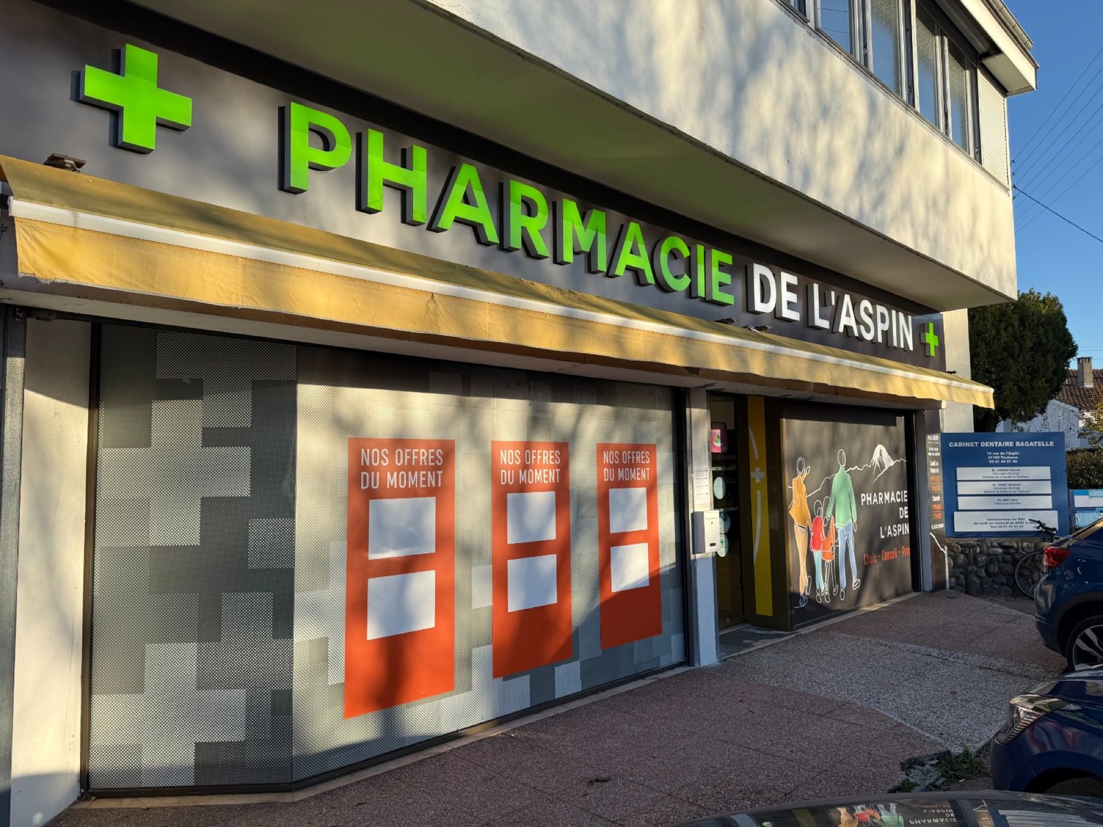 Façade rénovée de la Pharmacie de l'Aspin, enseigne verte et croix de pharmacie